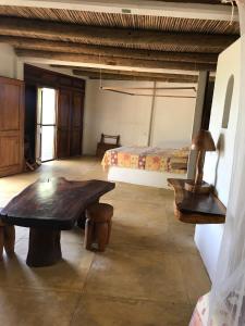 圣奥古斯蒂尼罗Cabañas Las 3 Marias的一间卧室配有一张床,并在客房内配有一张木桌