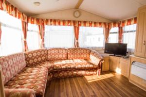 赫彻姆6 Berth Caravan For Hire, Minutes From A Stunning Beach In Norfolk! Ref 21036f的带沙发和电视的客厅