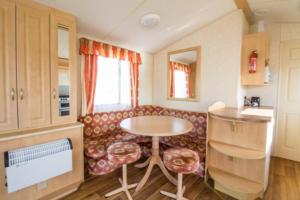 赫彻姆6 Berth Caravan For Hire, Minutes From A Stunning Beach In Norfolk! Ref 21036f的客厅配有桌子和沙发
