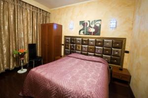 蒙卡列里班加西酒店的一间卧室配有一张红色床罩的床