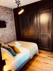 安锡HUDSON HIGHLANDS Annecy Rent Lodge的一间卧室设有一张床和砖墙