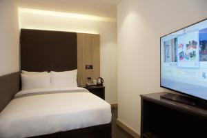 伦敦肖尔迪奇Z酒店的一间卧室配有一张床和一台平面电视