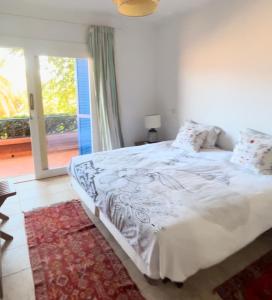 奥比丹Les Cactus的卧室配有一张大白色床和窗户