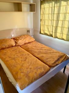 蒂萨菲赖德Tóparti Camping的一张床上的黄色毯子