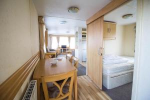 亨斯坦顿Wheelchair Friendly Caravan For Hire Norfolk Near The Beach Ref 13016l的小房间设有桌子和床