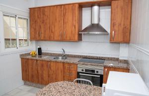 阿尔哈拉克Apartamentos Casa Tuli C, ALJARAQUE的一个带木制橱柜和水槽的厨房