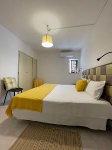 米尔芳提斯城Só Mar的一间卧室配有一张带黄色毯子的大床