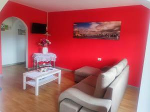 佩德罗佐Apartamentos turísticos Lemos的红色的客厅配有沙发和桌子