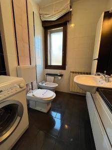 格拉多Appartamento Marchesini的浴室配有卫生间、盥洗盆和洗衣机。