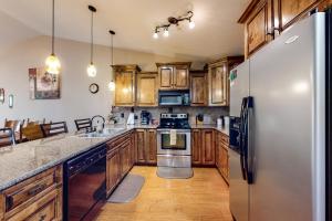 布兰森The Bluffs Lakeview的厨房配有木制橱柜和不锈钢冰箱。