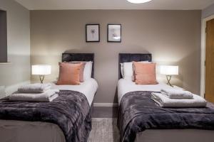 泰恩河畔纽卡斯尔Luxury apartment 5 min to city centre*free parking的一间卧室配有两张带枕头的床。