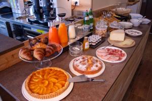 巴尔齐奥Garni Le Grigne的一张桌子,上面放着馅饼和糕点以及其他食物
