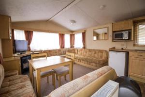 亨斯坦顿6 Berth Pet Friendly Static Caravan By Hunstanton Beach Ref 13011l的客厅配有沙发和桌子