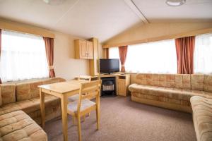 亨斯坦顿6 Berth Pet Friendly Static Caravan By Hunstanton Beach Ref 13011l的客厅配有沙发和桌子