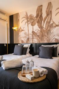 戛纳Hôtel Gallia Cannes的配有两张床和毛巾托盘的酒店客房