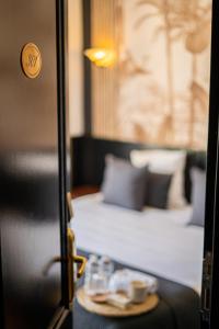 戛纳Hôtel Gallia Cannes的一间房间,里面设有床和桌子,上面有杯子