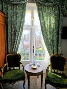 黑灵斯多夫Villa Bleichröder的一间设有两把椅子、一张桌子和一个窗户的房间