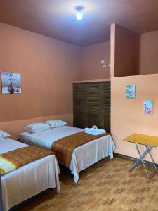 危地马拉Ciudad Vieja Bed & Breakfast Hotel的酒店客房设有两张床和一张桌子。