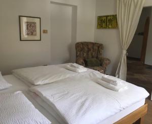 菲耶Apartment Maximilian的卧室配有白色的床和椅子