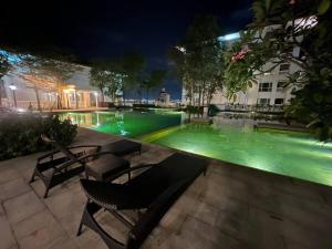 Bagan Jermal2Beds Seaview Straits Quay comes with Carpark and Hothub的游泳池,晚上有绿水