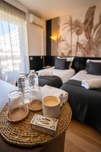 戛纳Hôtel Gallia Cannes的一间设有两张床和一张桌子的房间,桌子上备有杯子和饮料