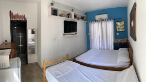 伯迪亚哥SUÍTE PRIVATIVA RIVIERA & ITAGUARÉ 100mts de 2 praias!的一间带两张床和电视的小卧室