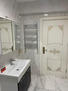 伊斯坦布尔AVRASYAQUEEN HOTEL的白色的浴室设有水槽和门