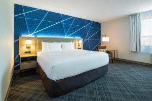 巴里巴里舒适汽车旅馆的一间卧室设有一张大床和蓝色的墙壁