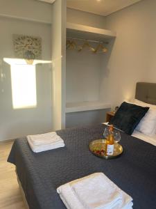 卡西奥皮Wave Luxury Apartments的一间卧室配有一张床和一个带一瓶葡萄酒的托盘