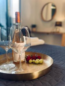 卡西奥皮Wave Luxury Apartments的一瓶葡萄酒和盘子上的葡萄