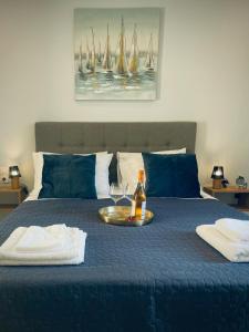 卡西奥皮Wave Luxury Apartments的床上装有一瓶葡萄酒和一杯玻璃的托盘