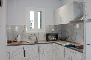 卡西奥皮Wave Luxury Apartments的厨房配有白色大理石台面和水槽