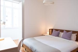 里斯本Amaro II - Sleek 2 bedroom apartment in Alcantara的一间卧室配有一张带紫色枕头的大床