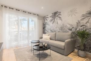 安锡CASABLANCA free parking的带沙发和棕榈树壁画的客厅
