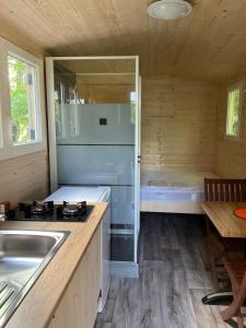 绍桑独木舟露营酒店的厨房配有炉灶、水槽和浴缸。