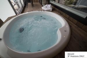 富良野富良野雅居公寓的浴室设有装满蓝色水的浴缸。