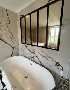 Saint-Vigor-le-GrandDOMAINE DU GRAND CAUGY的浴室设有白色浴缸及镜子