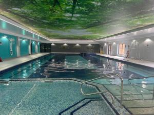 Saint Tudy55, Hengar Manor Estate的一座大型游泳池,其天花板上种有树木