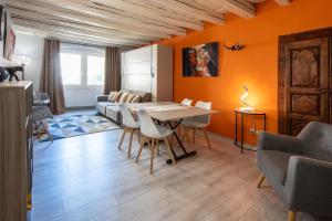 安锡FITZ ROY Annecy Rent Lodge的一间拥有橙色墙壁和桌椅的用餐室