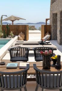 圣斯特凡诺斯Rocabella Mykonos Hotel的一个带桌椅的庭院和一个游泳池