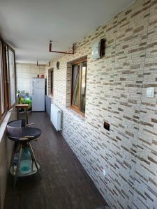 曼加利亚casa dana的一间设有砖墙和酒吧凳的房间