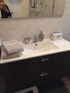OriaCasa Orchidea的浴室水槽配有毛巾和镜子