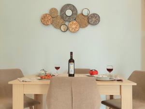 阿吉奥斯普罗科皮奥斯Kapris House的一张桌子,上面放着一瓶葡萄酒和两杯酒