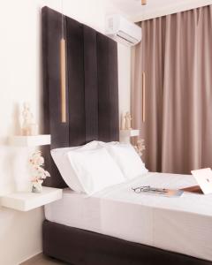 斯基亚索斯镇Atlas Suites的一间卧室配有一张白色的床和黑色床头板