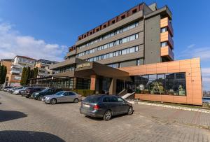 PaşcaniHOTEL CENTRAL Pascani的停在大楼前的一排汽车