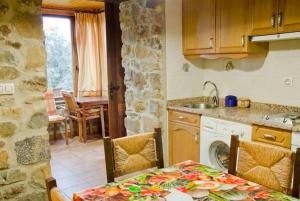 VillarCasa Rural La Lastría的厨房配有桌子、水槽和炉灶。