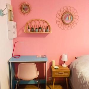 鲁昂Barbapappart - Un studio coloré dans le centre de Rouen的一间卧室配有书桌和粉红色的墙壁