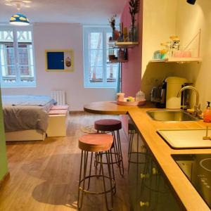 鲁昂Barbapappart - Un studio coloré dans le centre de Rouen的带2把酒吧凳的厨房和带1张床的厨房