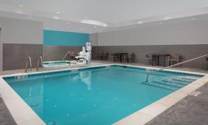 韦纳奇avid hotel Wenatchee, an IHG Hotel的大楼内一个蓝色的大型游泳池