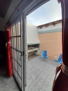 阿尔韦亚尔将军镇Casa amplia y cómoda的通往带两把椅子的庭院的开放式门